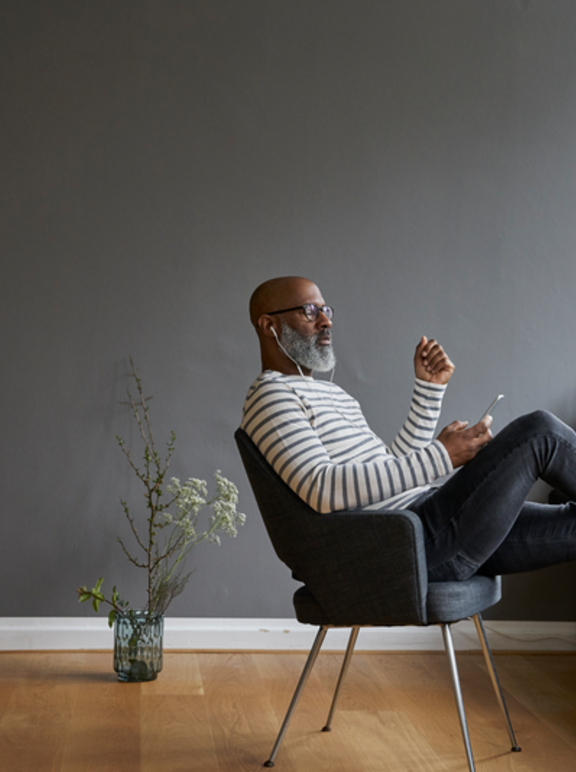 Mature man sitting with feet up, using smartphone 